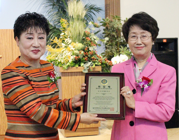 전임회장 강지원 목사가 신임회장 김헬렌 목사에게 취임패를 증정했다.