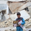 ▲폐허가 된 시리아에서 유니세프로부터 받은 불발탄 확인 안내 교재를 가지고 걸어가고 있다. 시리아 알레포 전역에 남아 있는 불발탄으로 어린이들이 생명을 위협받고 있다. 지난 12월 알레포 동부 지역에서 불발탄 사고로 어린이 6명이 사망하기도 했다. ⓒ유니세프 제공