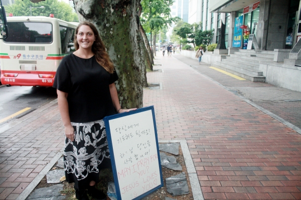 ▲길을 걷다 우연히 만나 마를리나 루미스. 그녀는 "당신에게 기도해도 될까요? 하나님은 당신을 사랑합니다"라고 적힌 팻말을 들고 서 있었다. ⓒ김진영 기자