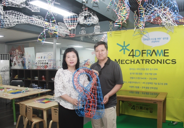 ▲포디랜드 양효숙 대표와 박호걸 소장이 본사 안에서 안팎 구별이 없는 클라인병 모형을 들고 포즈를 취했다. ⓒ이지희 기자