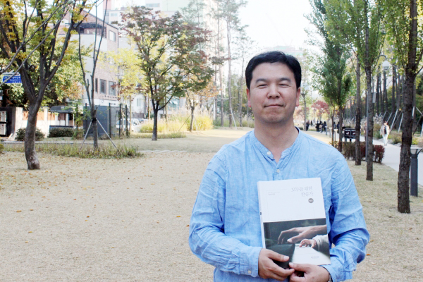 악보집 <모든 사람을 위한 찬송가 100>을 들고 있는 채윤성 목사