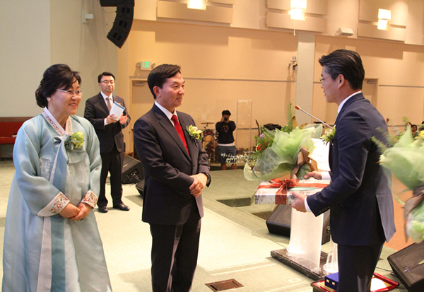 오명찬 담임목사(오른쪽)가 김인식 원로목사에게 꽃다발을 증정하고 있다.