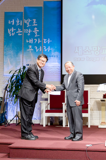 정승호 사무총장(좌)에게 안인권 목사(우)가 기금을 전달했다. 