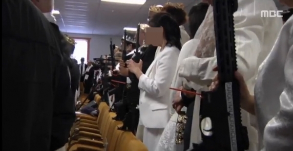 ▲소총을 든 채 합동결혼식 중인 통일교 생추어리 교회 신도들. ⓒMBC 캡처