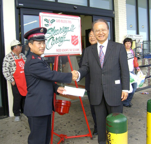 구세군 최다니엘 사관(왼쪽)과 성금을 전달하는 창고식품 신영교 대표(Atlanta Times 제공)