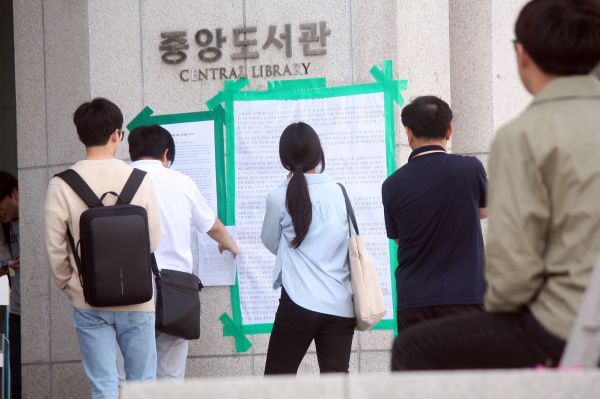 ▲연세대 중앙도서관 앞에 걸린 은하선 씨 강연 관련 대자보를 유심히 읽고 있는 학생들. 