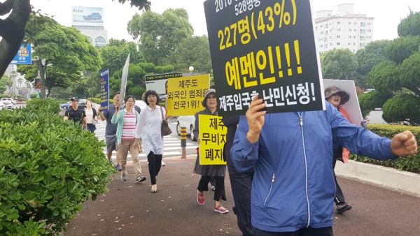 ▲제주난민대책도민연대가 최근 제주도청 로타리에서 도의회실까지 피켓 행진을 하던 모습. ⓒ제주난민대책도민연대