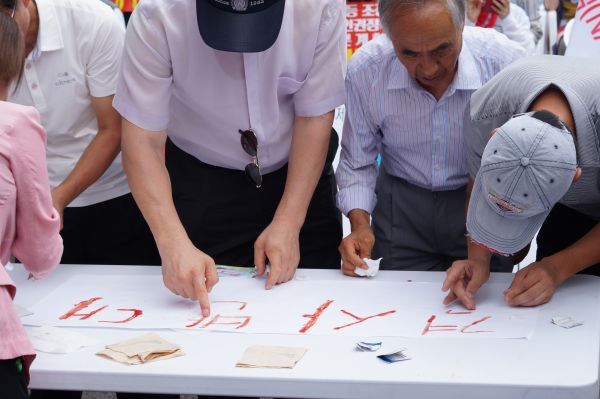 ▲제3차 국가인권정책 기본계획(NAP) 폐지를 요구하며 혈서를 쓰는 목사들. ⓒ김신의 기자