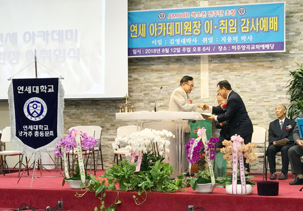 김영대 전임 원장이 지용덕 신임 원장에게 취임패를 증정하고 있다.