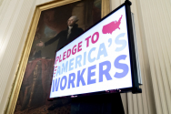 지난 6월26일 백악관에서 조시 워싱턴 초상화 아래에서 미국 노동자들과의 서약 화면이 송출되고 있다.