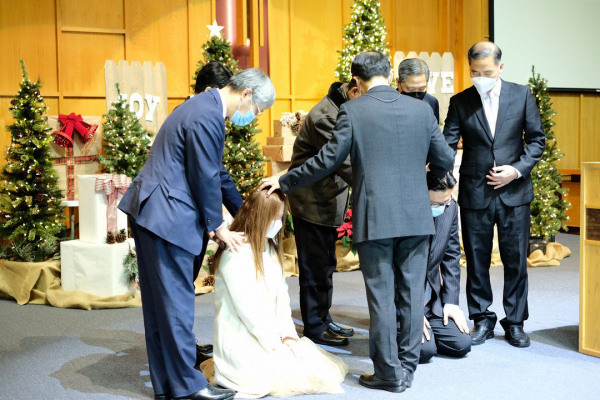 타코마중앙장로교회 임직식에서 이형석 목사가 방세라, 윤영중 안수집사에게 안수 기도하고 있다.