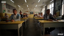 중국 정부가 신장 지역에 설립한 ‘훈련 교육 센터’에서 수감자들이 수업에 참여하고 있다. ⓒBBC 보도화면 캡쳐