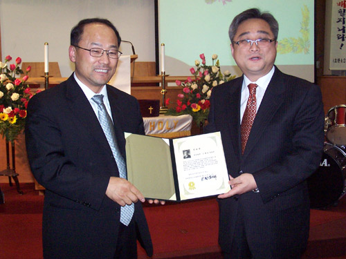 신임회장 송성모 목사(왼쪽)가 직전회장 은회곤 목사(오른쪽)에게 감사장을 전달하고 있다.