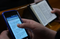 한 교회에서 스마트폰으로 성경을 검색하는 성도와 성경책을 읽는 성도의 모습.