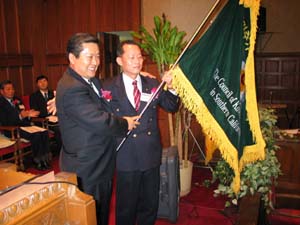 전직 정해진 회장이 신임 최학량 목사에게 교협기를 인계하고 있다