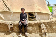 파키스탄 홍수 피해 당시 세이브더칠드런에서 제공한 텐트 앞에 앉아있는 아메드 칸(8세, 가명). ⓒ세이브더칠드런 제공