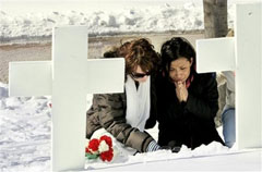 지난 15일, Linze Griebenow and Raquel Vega라는 NIU학생이 학생회관 외부에 있는 십자가 앞에서 희생자들을 애도하고 있다