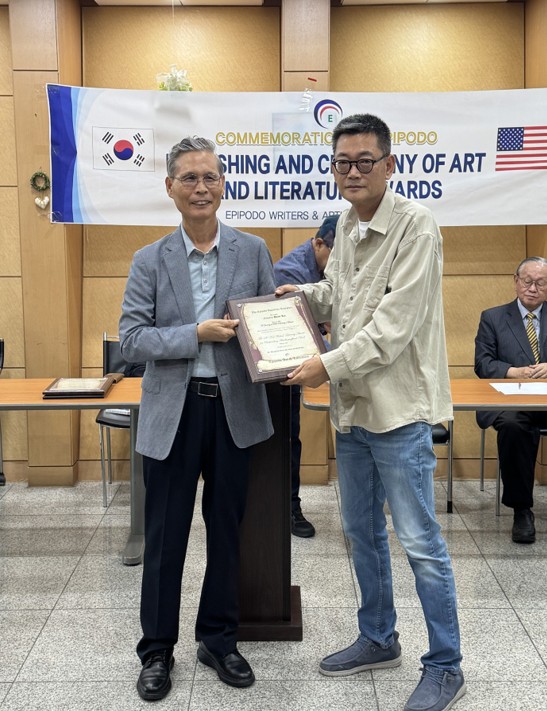 에피포도 예술과문학 대표 백승철 목사가 소설가 이훈구 에게 시상하고 있다.