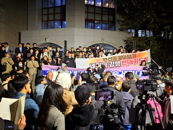 '변선환 알아보기' 세미나 반대 측이 계단 위에 서서 세미나 주최 측을 향해 항의하고 있다. 그 아래 분홍색 현수막은 행사 주최 측의 것. ©노형구 기자