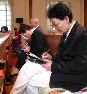 뉴욕영광장로교회 교인이 기아 아동을 후원하기 위한 약정서를 작성하고 있다.