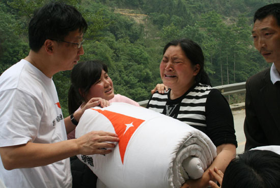 월드비전 홍콩 케빈 추 회장이 칭추안 시의 직접 지진 피해자들에게 누비이불을 나누어 주고 있다. ⓒ월드비전