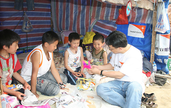 월드비전 홍콩 회장이 월드비전이 제공한 임시 텐트에 머물고 있는 어린이들을 위로하고 있다.ⓒ월드비전