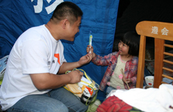 월드비전 직원이 한 어린이에게 장난감을 나누어 주고 있다.