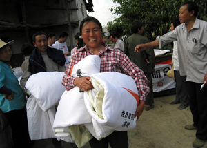 쓰촨성 지진 사태의 피해자가 월드비전이 배급하는 구호 물품으로 받아 가고 있다.