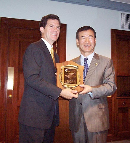 최성규 목사(우)가 샘 브라운백 상원의원(좌)에 감사패를 전달하고 있다.