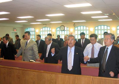 교협회장단 임원들이 손에 손을 붙잡고 할렐루야 대회를 위해 통성기도를 하고 있다.