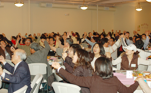 참석자들이 손에 손을 잡고 찬양을 부르고 있다. 