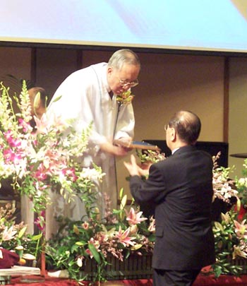 당회장인 한진관 목사가 25년 이상 공로교인에게 기념패를 증정하고 있다