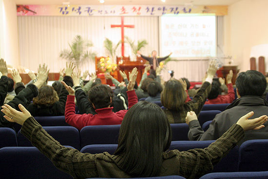 본당을 가득 메운 성도들이 두손을 들고 찬양을 하고 있다.