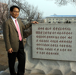 목회자들과 함께 방북한 우리민족교류협회 송기학 이사장이 김일성 광장에 세워진 김정일을 찬양하는 기념비에서 포즈를 취하고 있다. 이 수령비는 “위대한 령도자 김정일 동지께서는”으로 시작해 “어버이 수령님의 은정깊은 사랑을 한시도 잊지 말고 수령님을 더 잘 모실데 대하여 말씀하시었다”로 끝난다.