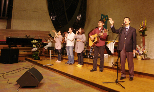 심형섭 목사의 인도로 '부르신 곳에서'를 다함께 찬양하고 있다.