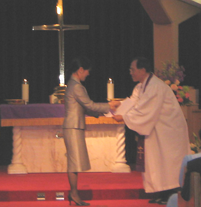 나구용 목사로 부터 만불을 수여받는 모습