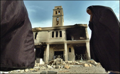이라크 여성들이 테러를 당한 교회를 지나쳐 걸어가고 있다. ⓒ AFP / Jewel Samad
