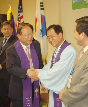 송병기 목사가 새로 총회장에 선출된 황천영 목사(오른쪽)에게 축하의 말을 전하고 있다. 