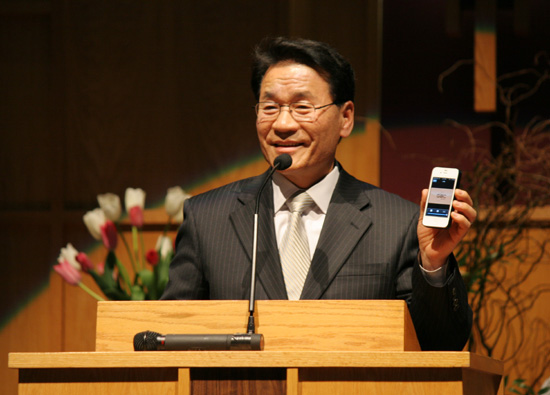 이날 예배가 스마트 폰 어플리케이션에서 동시에 중계되고 있음을 설명하는 이상진 장로ⓒ김브라이언 기자