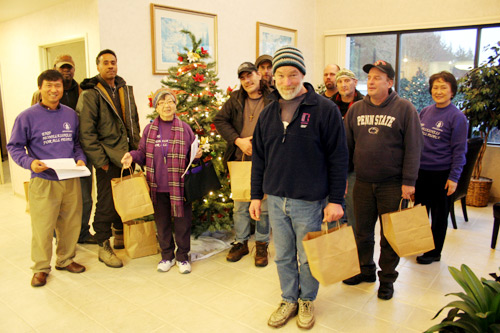 둥지선교회가 준비한 선물을 나누며 기뻐하는 둥지선교회 임원들과 노숙자들