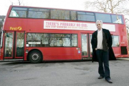 리차드 도킨스 교수가 ‘하나님은 없다’라는 문구의 버스 광고 앞에서 포즈를 취하고 있다