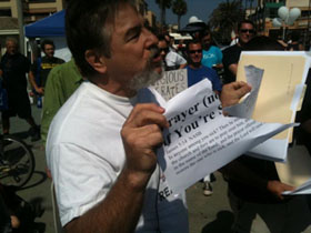 과거 열렸던 한 무신론자 집회에서, 참석자가 성경구절이 인쇄된 종이를 찢고 있는 모습.