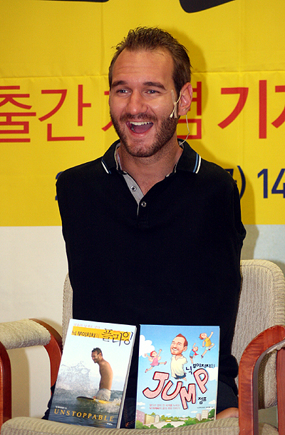 저서를 소개하며 환하게 웃고 있는 닉 부이치치.