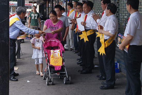 찬양하는 가운데 행인에게 홍보전단을 전달하고 있다.