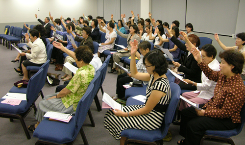 여선교회 회원들이 함께 손을 들고 찬양하는 모습