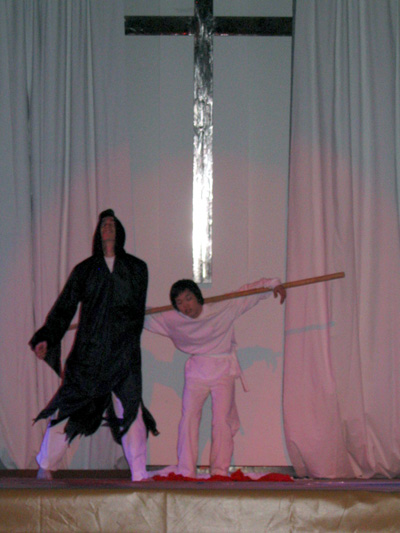 뮤지컬 ''죽임당하신 어린양'' 중 한 장면. 예수님께서 십자가를 지고 힘겨운 고난을 당하고 계시다.