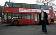 하나님은 없다’는 버스 광고 앞에서 포즈를 취하고 있는 도킨스 박사