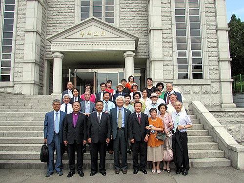 참석자들이 평양 봉수교회 앞에서 기념촬영을 하고 있다. (앞줄 왼쪽부터 순서대로) 배태진 기장 총무, 전용재 감독회장, 강명철 위원장, 김영주 총무, 박동일 기장 총회장. ⓒNCCK 제공