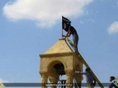 IS 대원들이 교회 첩탑의 십자가를 철거한 뒤 IS 깃발을 꽂고 있다. ⓒ트위터