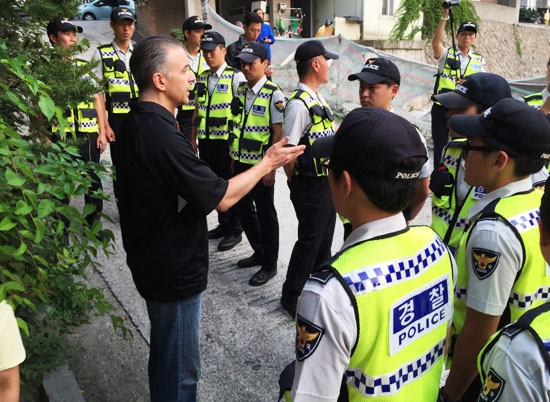 지난 23일 순교자의 소리 CEO 에릭 폴리 목사(맨 왼쪽)가 사무실 앞을 지키고 있는 마포경찰서 소속 경찰들에게 풍선 사역에 대한 의도 등을 설명하고 있다 ©한국 순교자의 소리